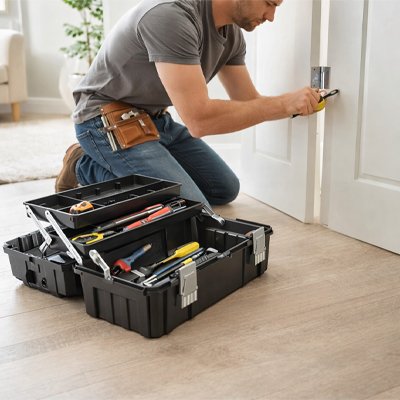 Homme répare porte avec caisse a outils