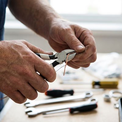 Bricoleur utilise pince coupante pour couper fil métal
