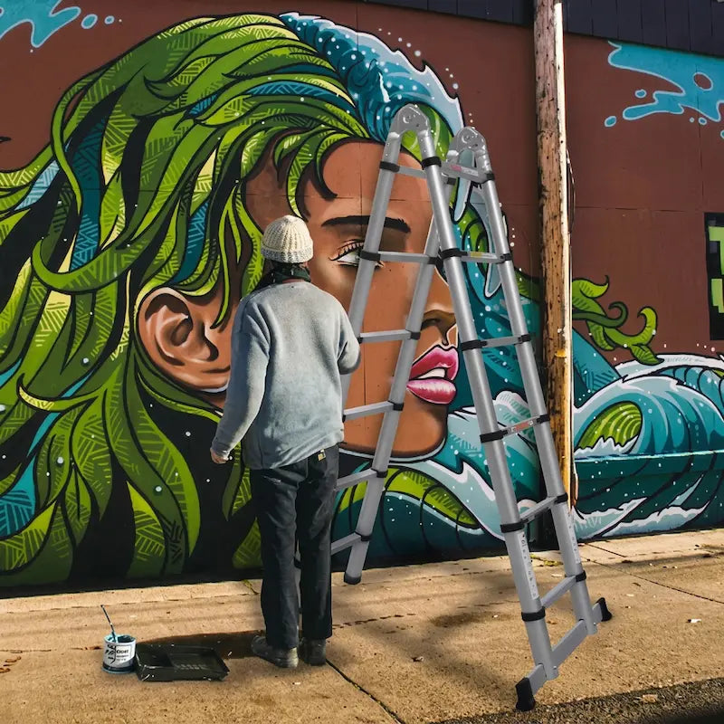 Femme devant mur graffitis avec echelle telescopique