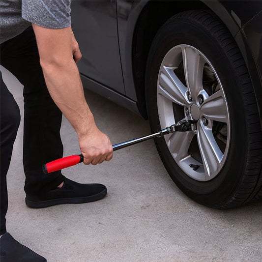 Homme ajuste boulon roue d'automobile avec clé à cliquet