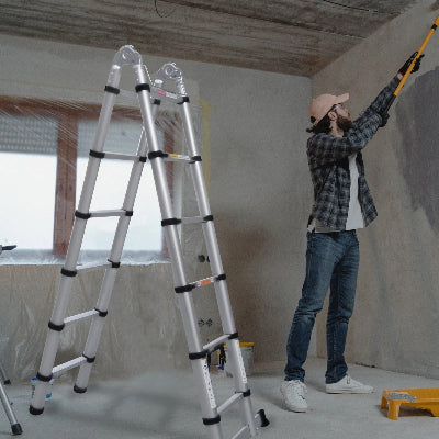 Homme qui bricole utilisant echelle telescopique