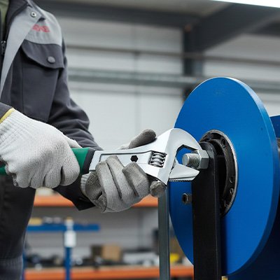 Homme utilise clé à molette pour ajuster boulon industriel