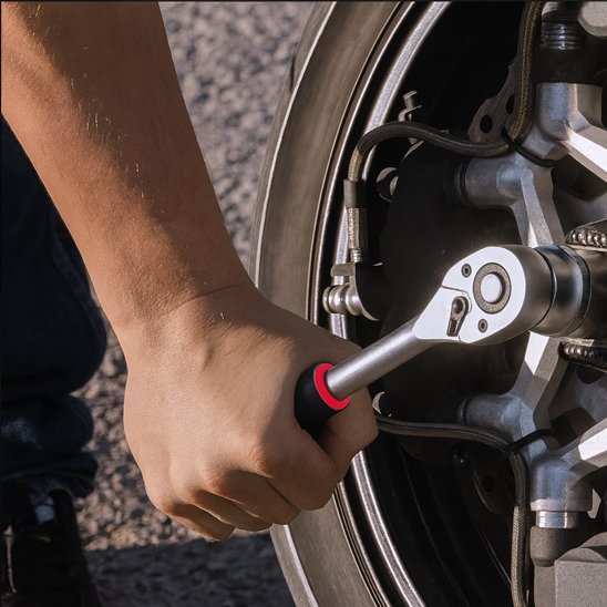 Homme utilise jeu de cles a douille pour roue de moto