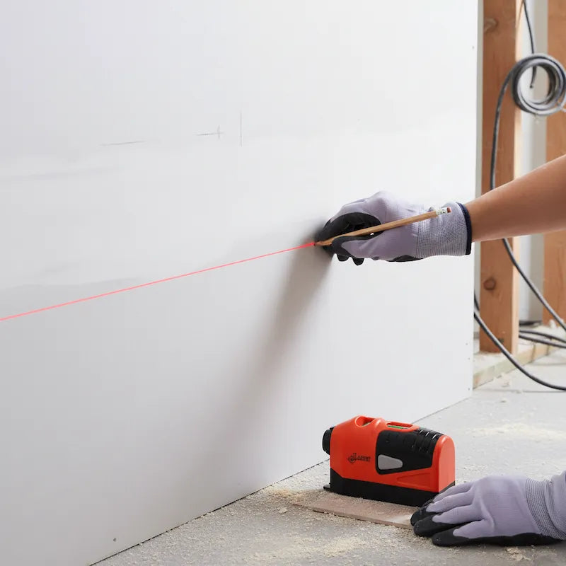Homme utilise niveau laser à bulle pour marquer lignes