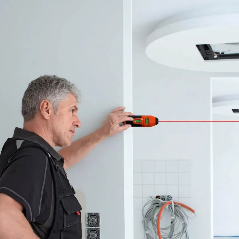 Homme utilise niveau laser à bulle pour mesurer