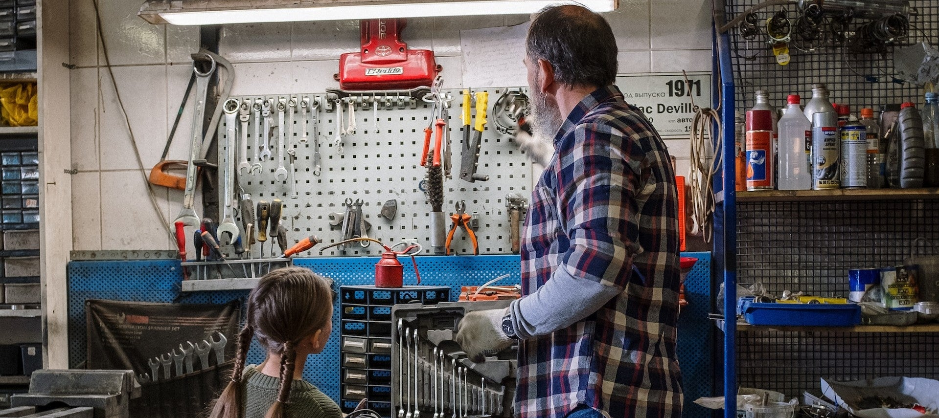 Père et fille regardant outils devant établi