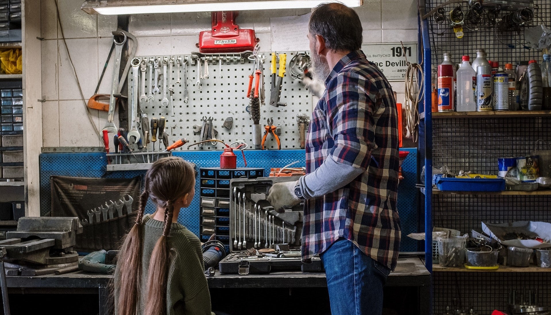 Père fille regardent outils devant établi