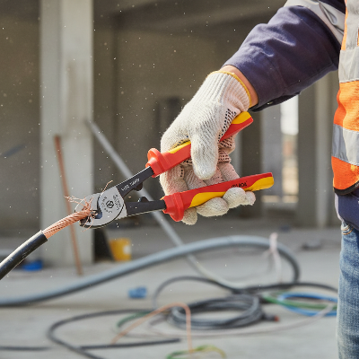 Travailleur chantier utilise pince coupante electricien pour couper fil